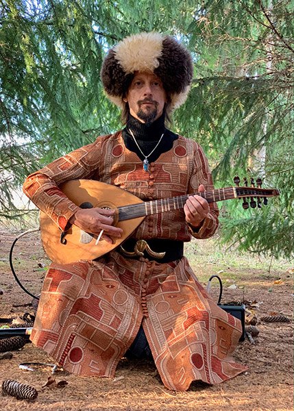 Thomas Moore performing as Chickpeazio with a stringed instrument